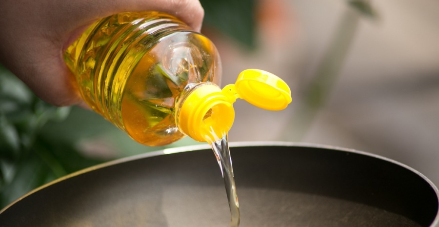 Pouring food oil in hot pan for deep frying.