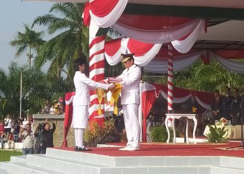 Bupati Batanghari, saat serahkan Bendera Merah Putih kepada pembawa Baki  Adelia Putri( Poto Shely G12)