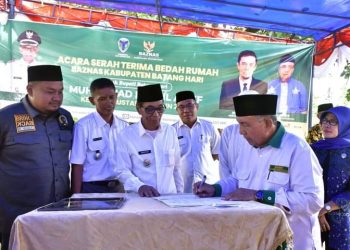Wakil Bupati Batanghari bersama ketua Baznaz dalam penanda tanganan serah terima bedah rumah(Poto ist)