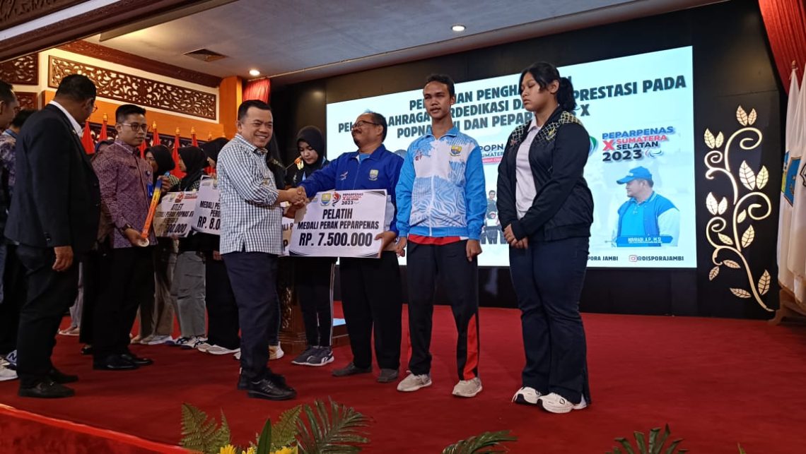 Gubernur Jambi DR. H. Al Haris, S.Sos, MH., saat menyerahkan bonus kepada pelaku olahraga berdedikasi dan berprestasi pada Popnas XVI dan Peparpenas X yang berlangsung di Sumatera Selatan Tahun 2023 lalu. (Gambar: Diskominfo Provinsi Jambi)